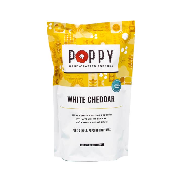 A bag of Poppy Hand-Crafted White Cheddar Popcorn with yellow and white packaging.