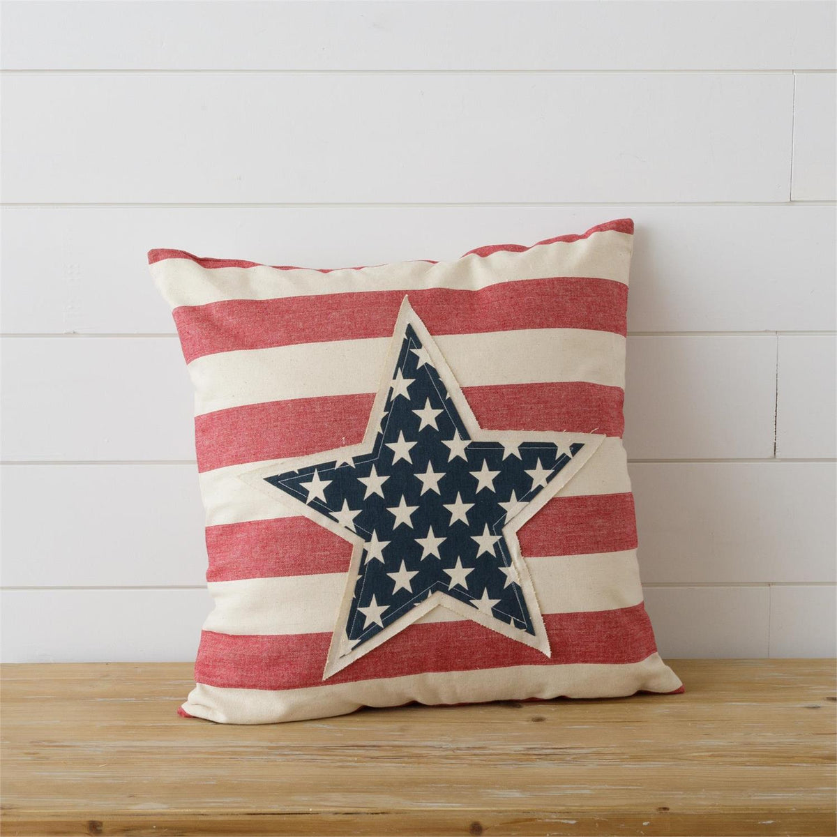 Square cotton pillow with patchwork stripes in neutral tones.