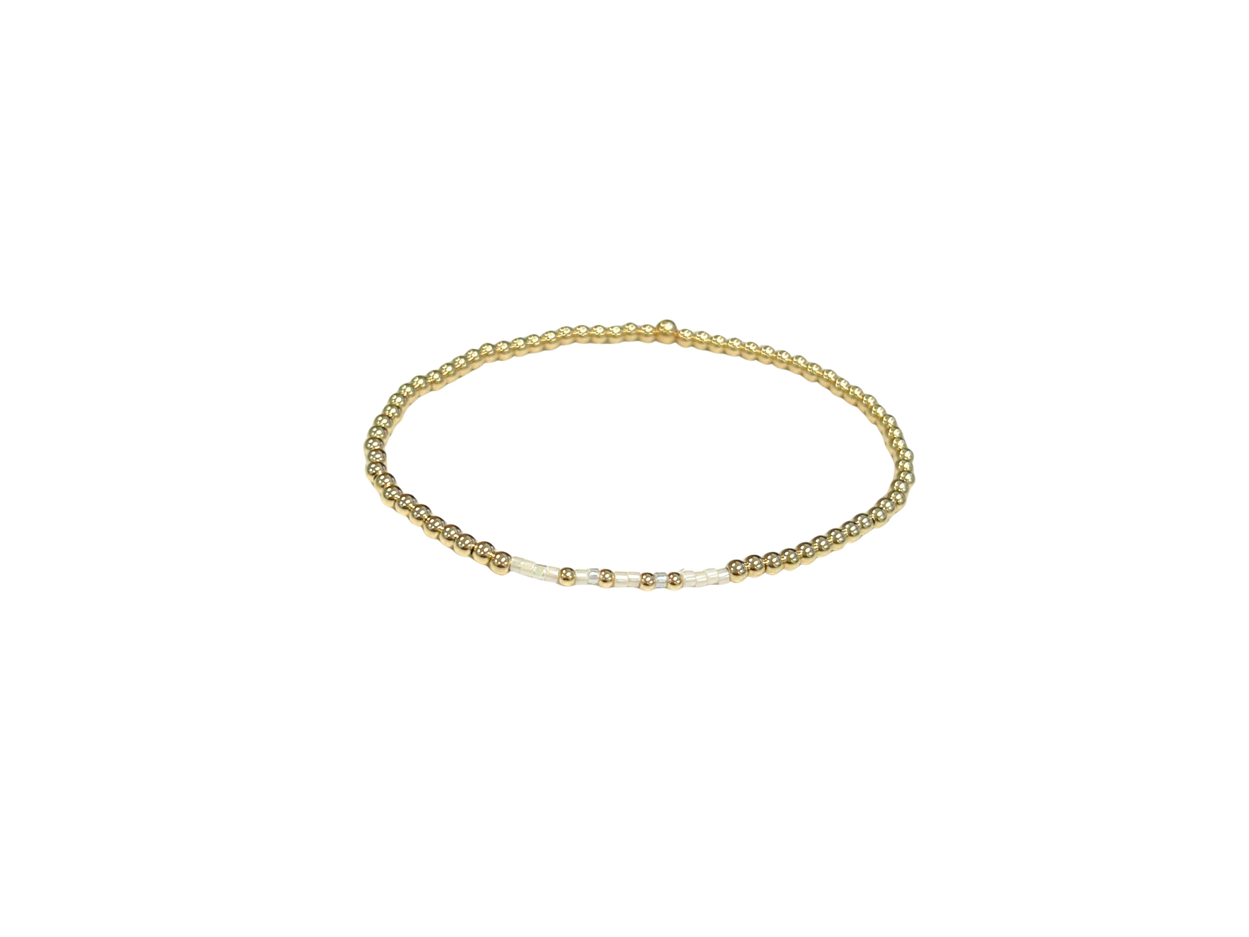 Faith Bracelet featuring 2.5mm 14K gold-filled beads and white accent beads on an elastic band.