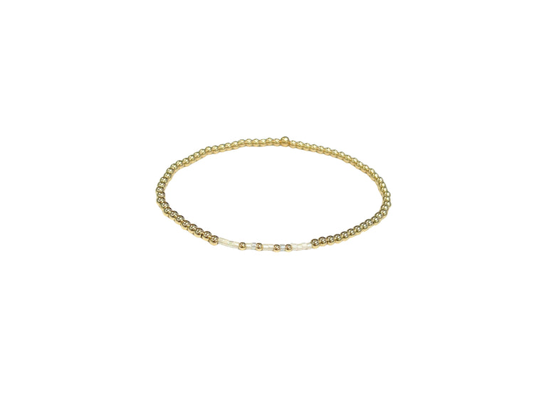 Faith Bracelet featuring 2.5mm 14K gold-filled beads and white accent beads on an elastic band.