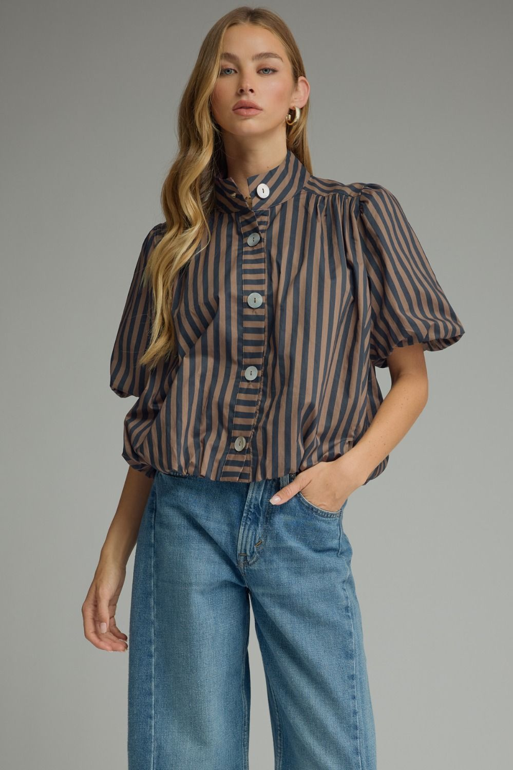 Woman wearing the Camila Stripe Short Puff Sleeve Top in brown and navy with blue denim jeans.