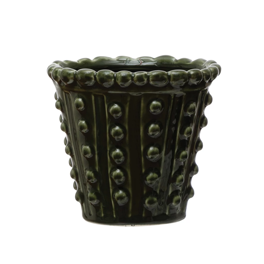 Round green stoneware hobnail planter with solid bottom holding a succulent.