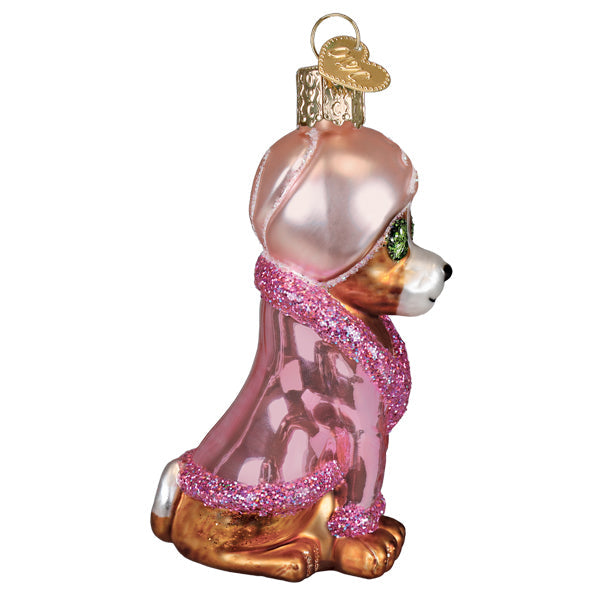 Glass Spa Dog ornament wearing a pink robe and head wrap with cucumber slices over its eyes.