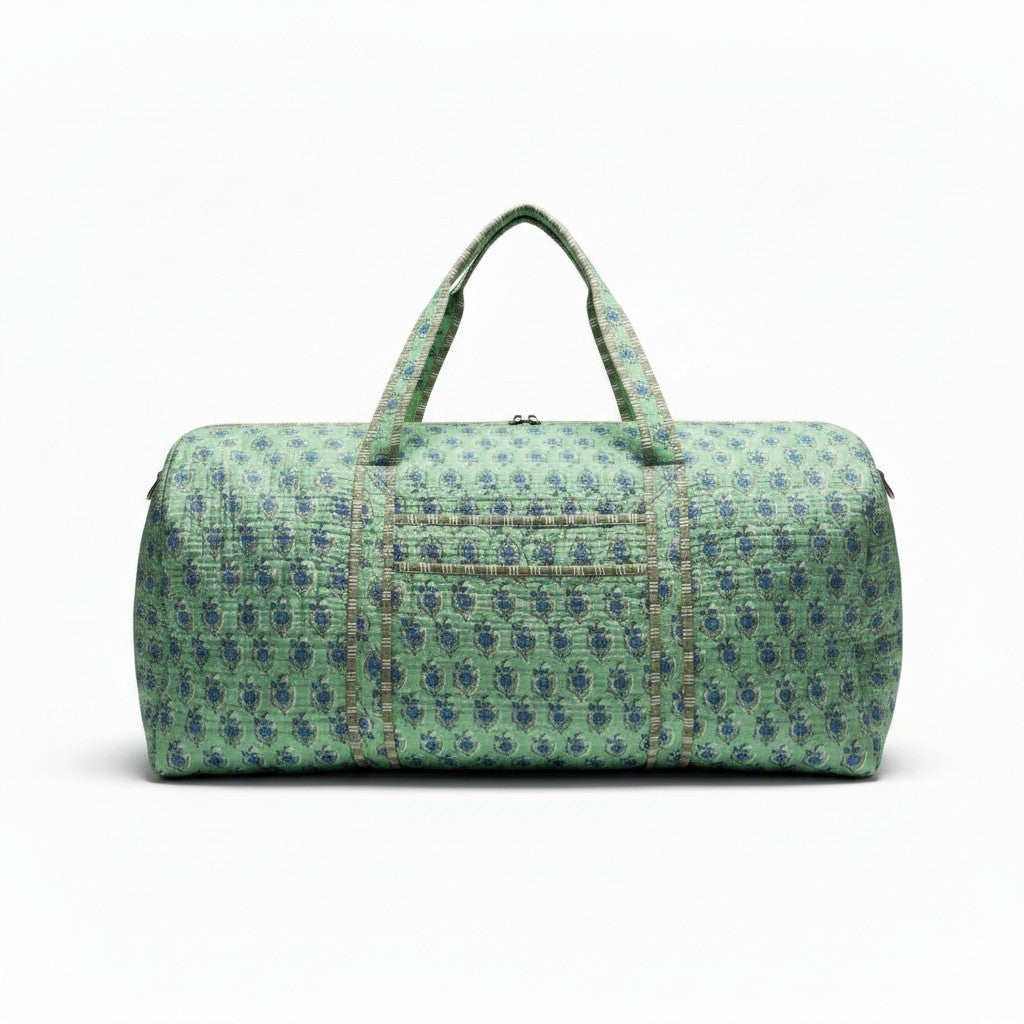 Quilted teal duffel bag with a blue floral pattern and matching top handles.