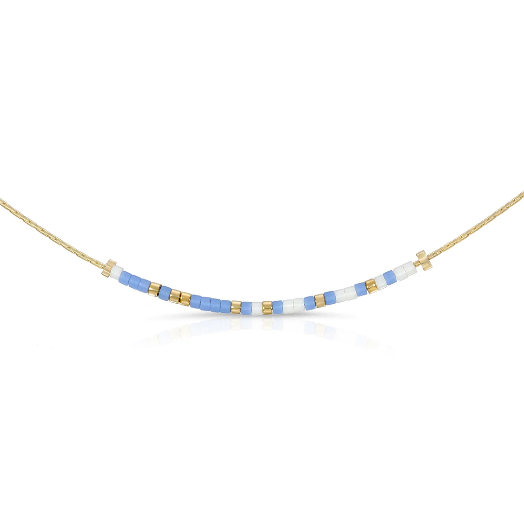 Be Happy Necklace featuring matte periwinkle blue and luster white beads on a gold chain.