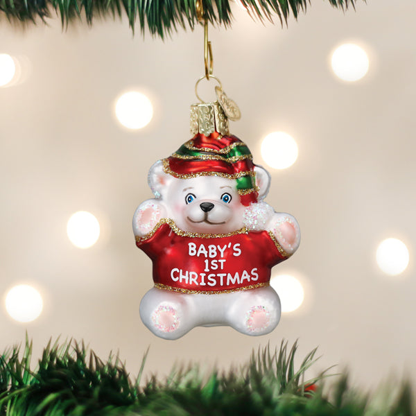 White glass teddy bear ornament wearing a red sweater that says Baby's 1st Christmas.
