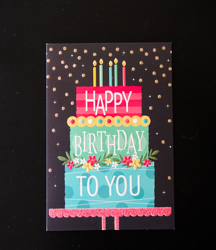 Neon foil embossed birthday card shaped like a cake with 'Hugs Kisses' text.