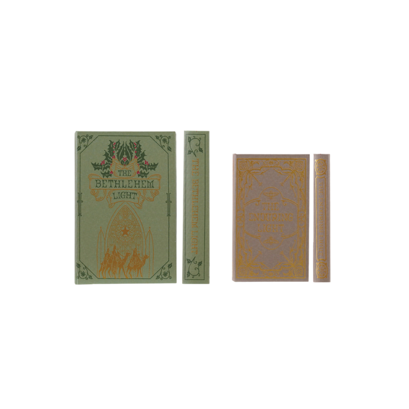 Set of two green and tan canvas book storage boxes with vintage Christmas prints and gold details.