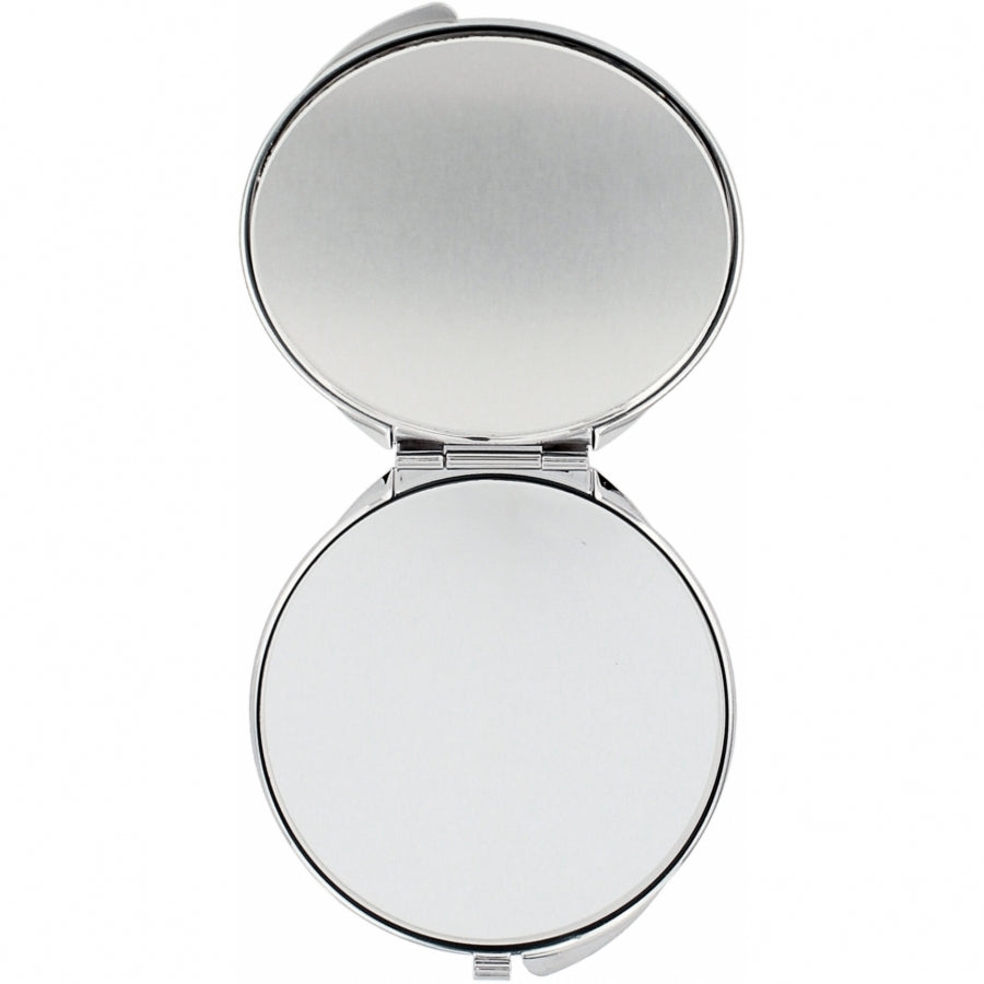 Silver plated compact mirror with pressure retractable closure and one side offering 2.5x magnification.