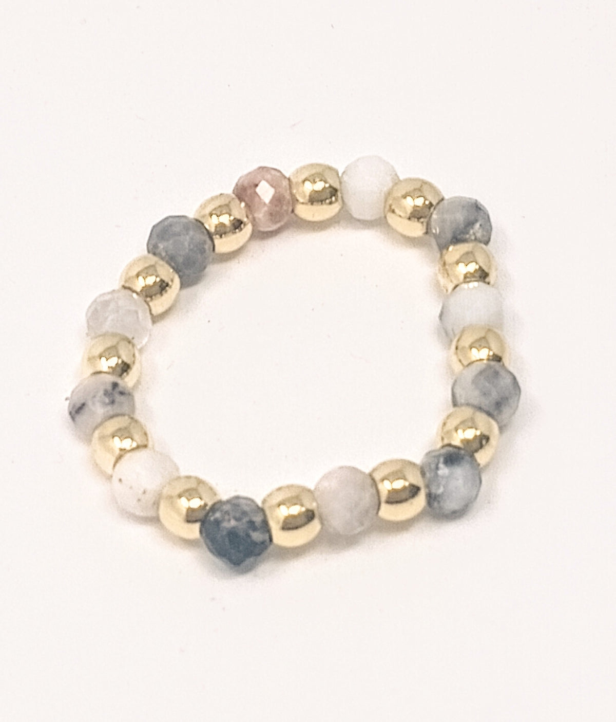 Stretch ring featuring 3mm gold-tone beads and multi-colored semi-precious stone beads.