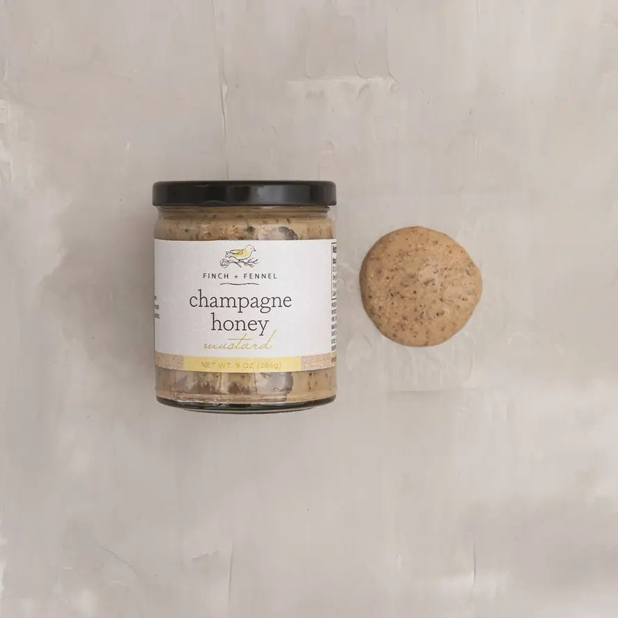Jar of Champagne Honey Mustard sauce with a honey-colored lid.