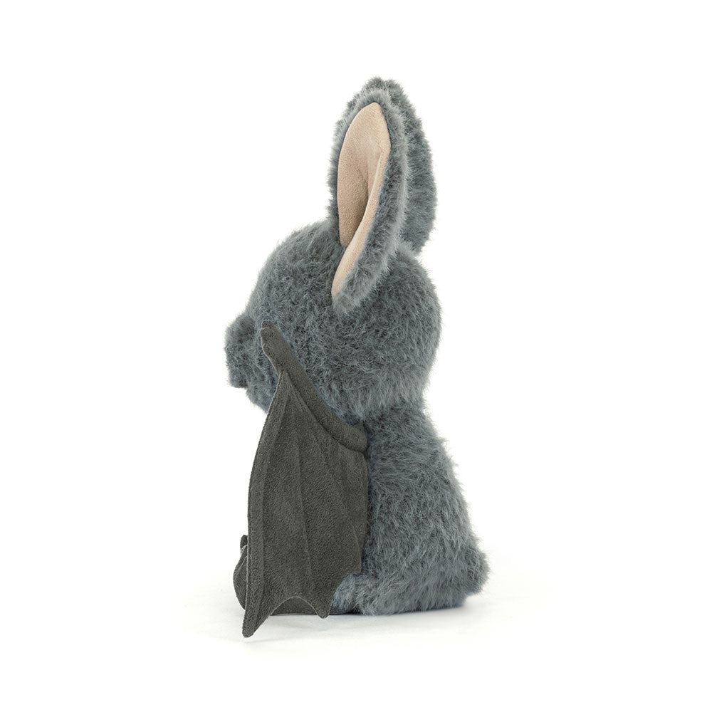 Side view of Broox Bat, a grey fuzzy plush toy with large ears and dark grey wings.