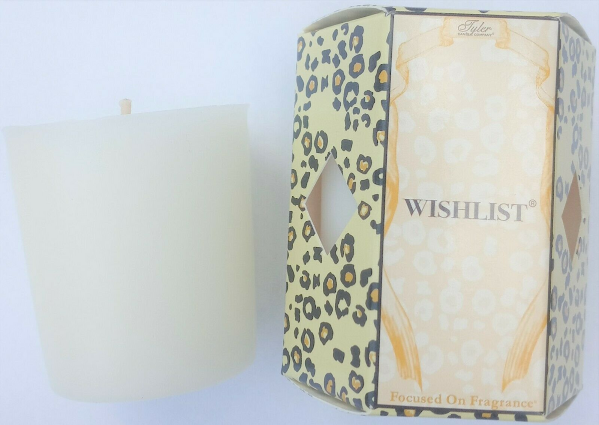 A white votive candle next to a "Wishlist" candle box with a leopard print pattern.
