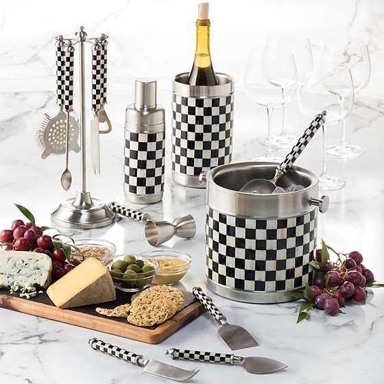 Courtly Check ice bucket with matching barware, wine chiller, and cheese board on a marble surface.