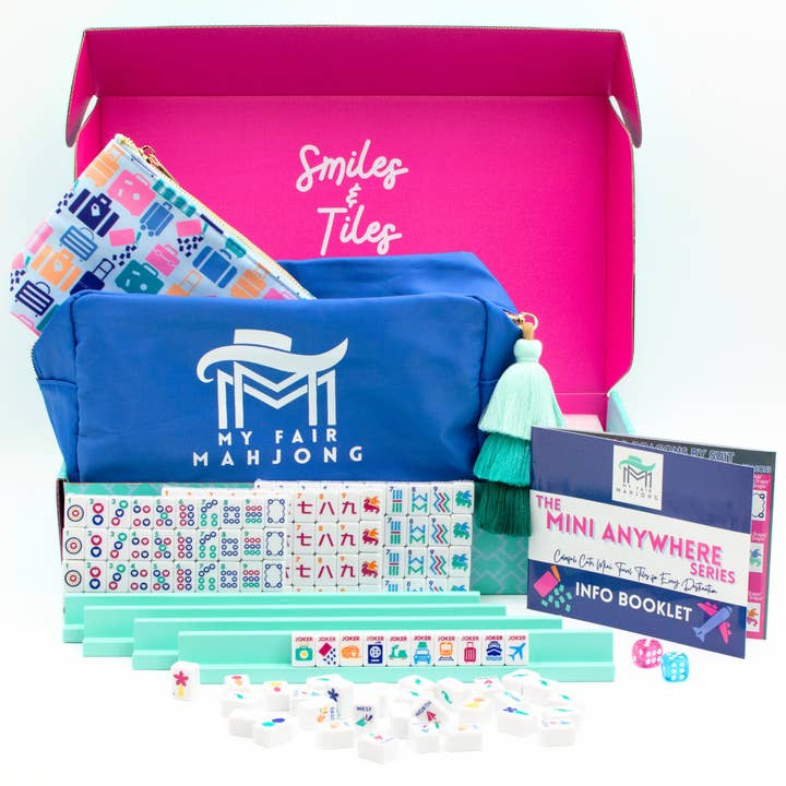 Mini Travel Mahjong set with blue carrying case, tiles, racks, and info booklet in a pink box.