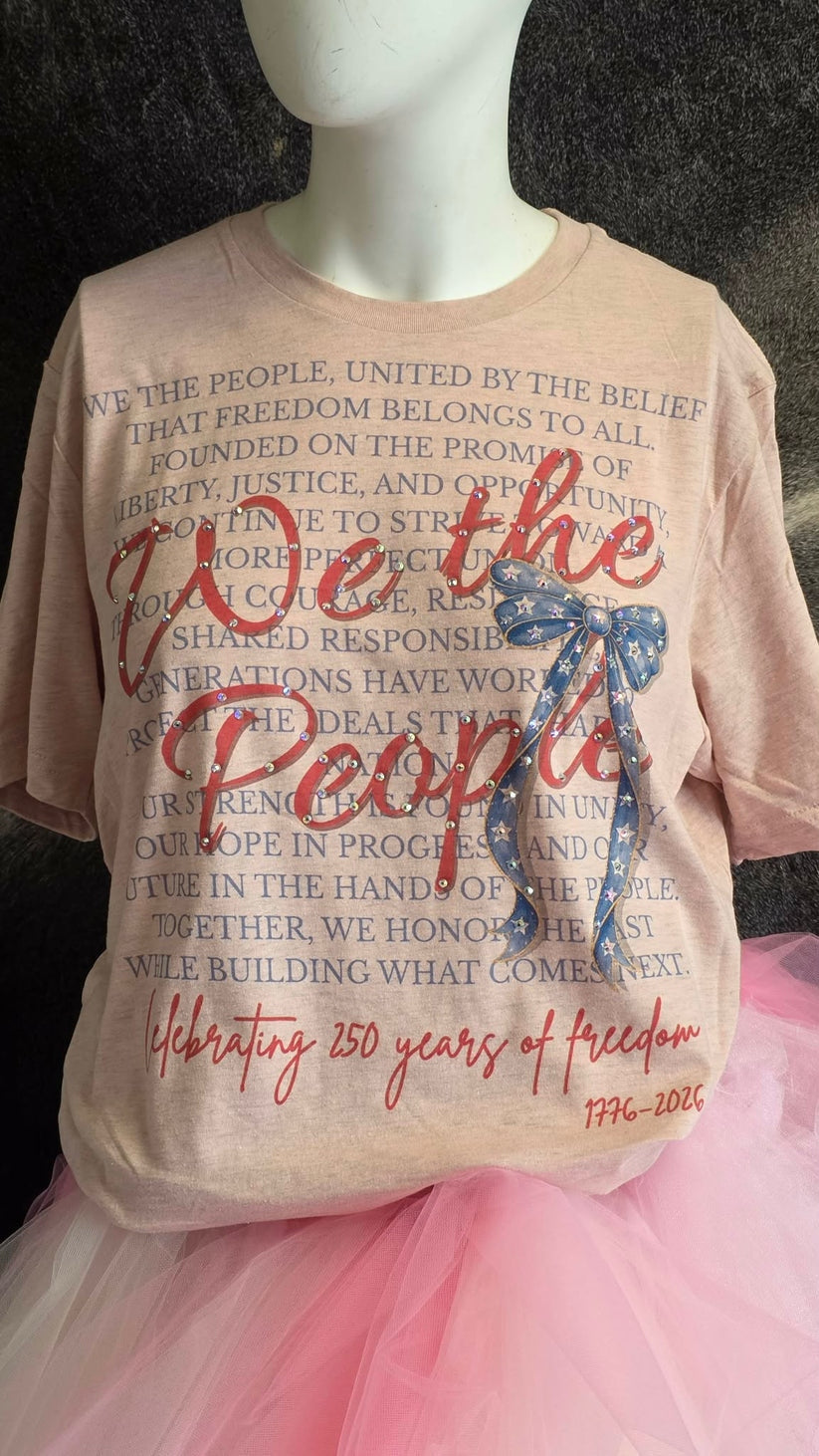 Heather Prism Peach t-shirt with 'We the People' text, a blue star bow, and 250 years of freedom.