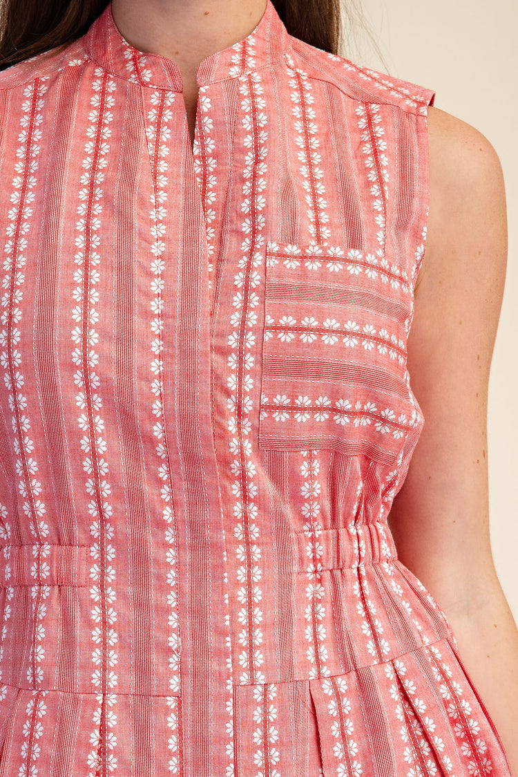 Close-up of a sleeveless red and white embroidered boho shirt dress with a cinched waist.