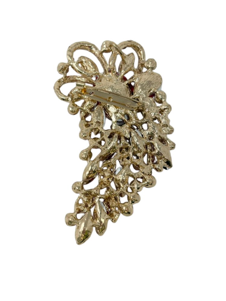 Back view of a gold-tone red gemstone brooch showing the pin clasp and intricate metalwork.