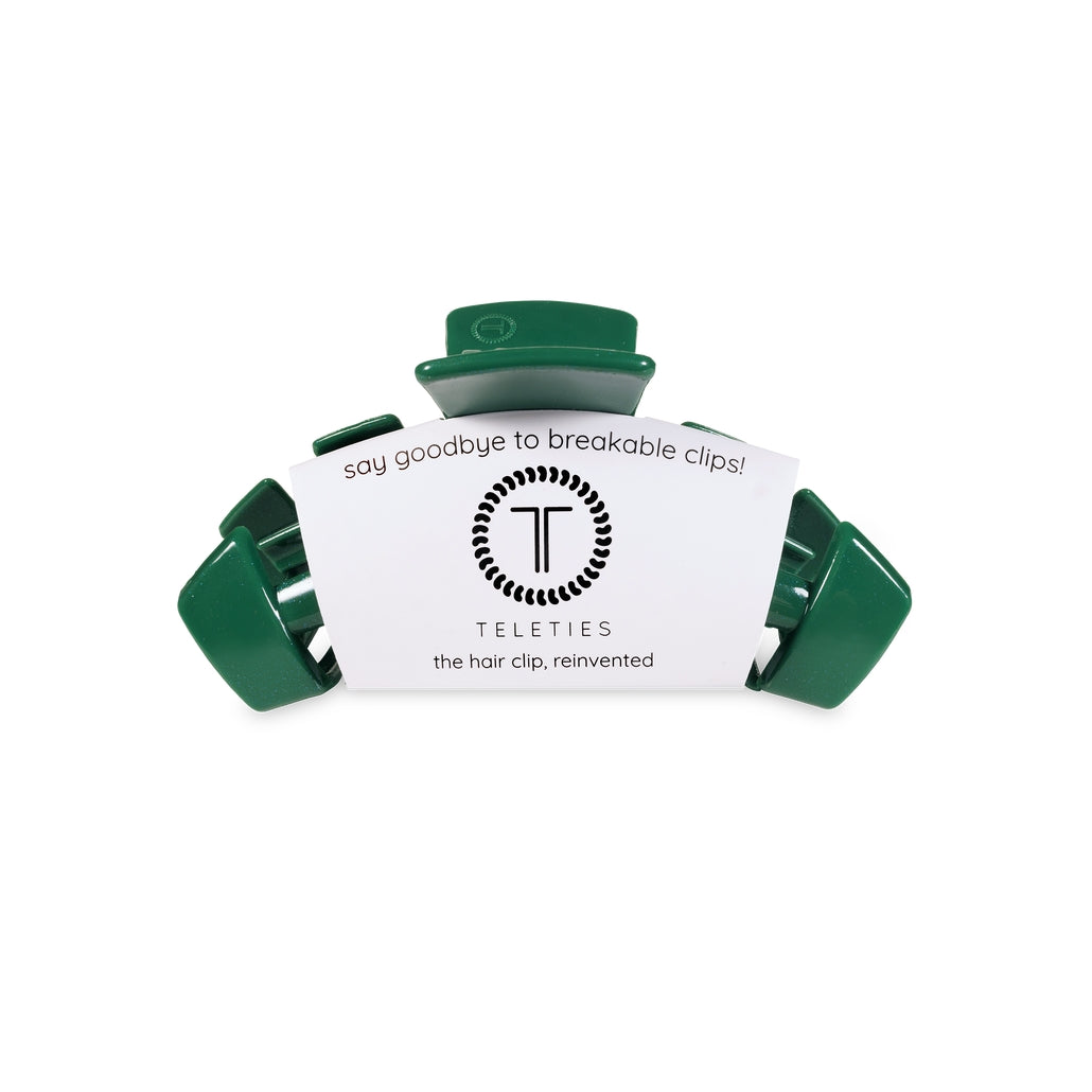 Small dark green Teleties hair clip with white brand packaging on a white background.