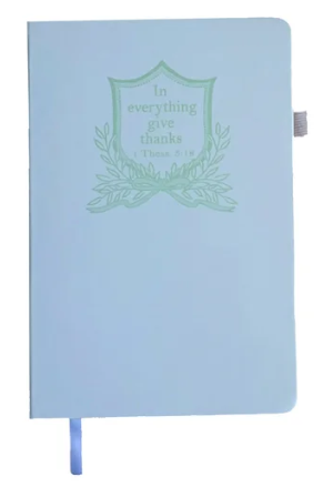 Light blue Standing On The Word Journal with 'In everything give thanks' and a green crest design.