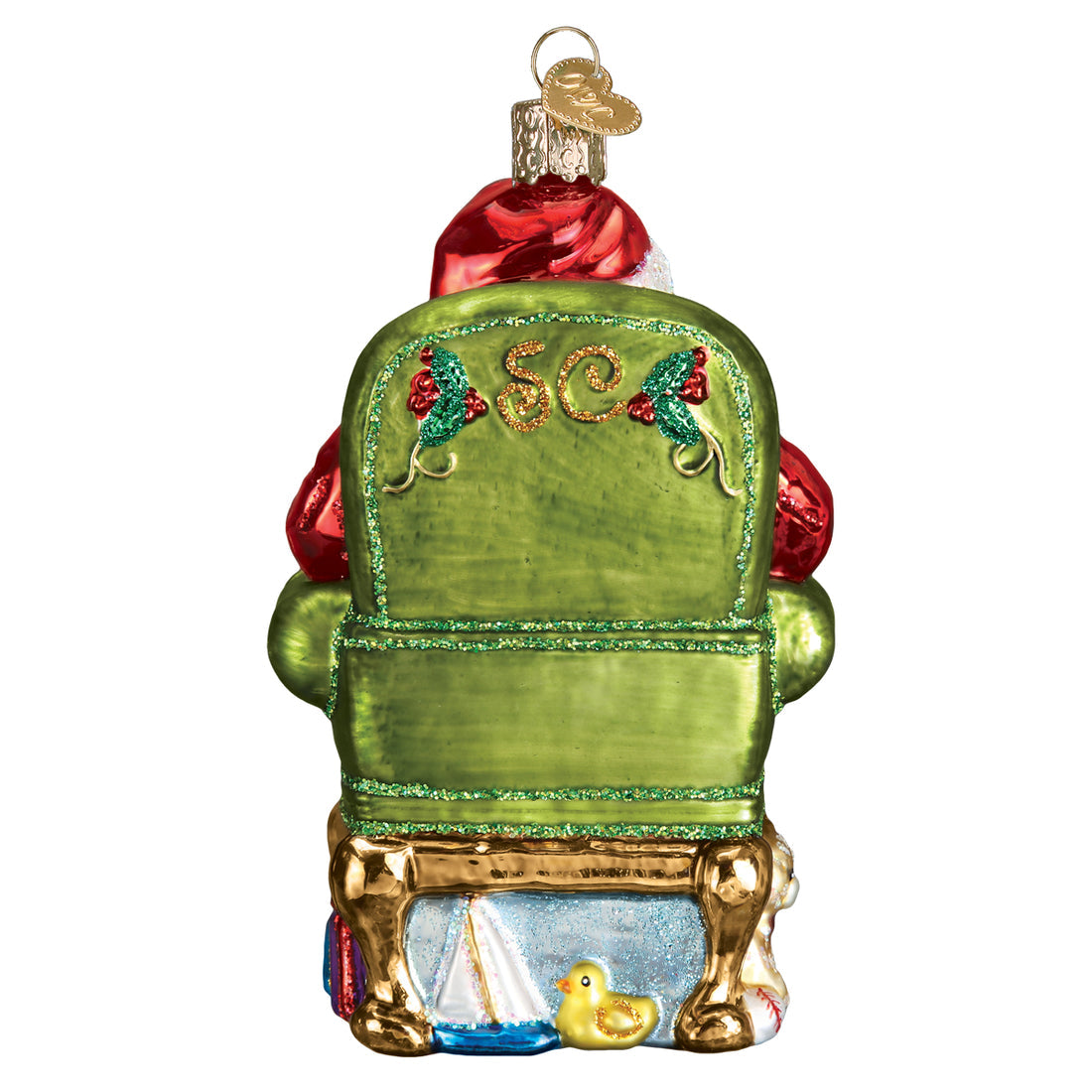 Back view of a glass Santa ornament in a green chair with gold SC initials and toys underneath.