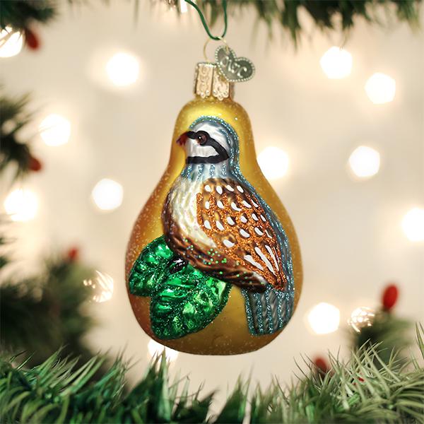 Glass Partridge in a Pear Tree Christmas ornament with glitter accents hanging on a tree.