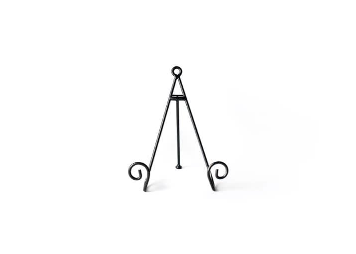 Black metal mini plate stand with a curled swirl design on a neutral background.