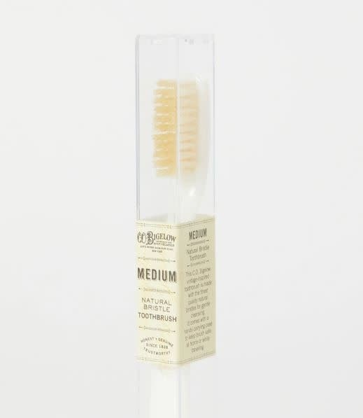Natural boar bristle toothbrush with medium softness on an ivory handle.