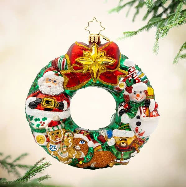 Jingle All the Way wreath featuring Santa, reindeer, snowman, and gingerbread man figures on a festive background.