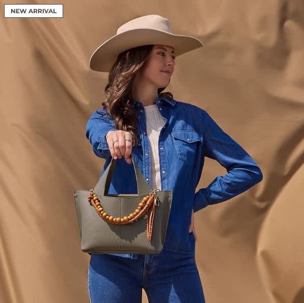Vida small tote in biscuit leather with antique brass hardware featuring a center zip pocket and removable strap.