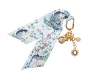 Peacock Paradise bag charm featuring a peacock feather motif with iridescent blue and green accents on gold-tone metal.