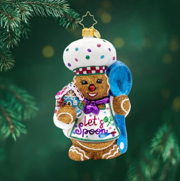 Gingerbread baker figurine in festive red outfit holding sweet treats