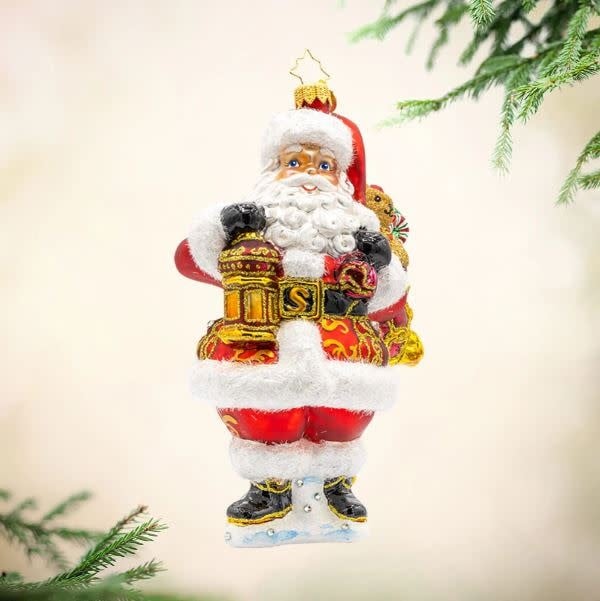 Jolly Santa figurine in red suit holding a lantern with a teddy bear companion.