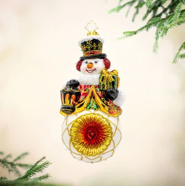 Radko Radiant Reflections Snowman ornament with glittering body, gem accents, red lantern hat, and reflective silver base.