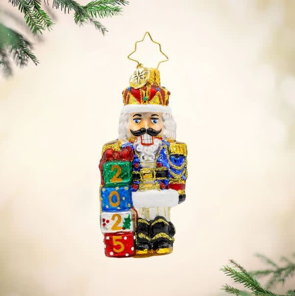 Royal Gift Guardian nutcracker figurine with gold crown jewel accents on a dark base