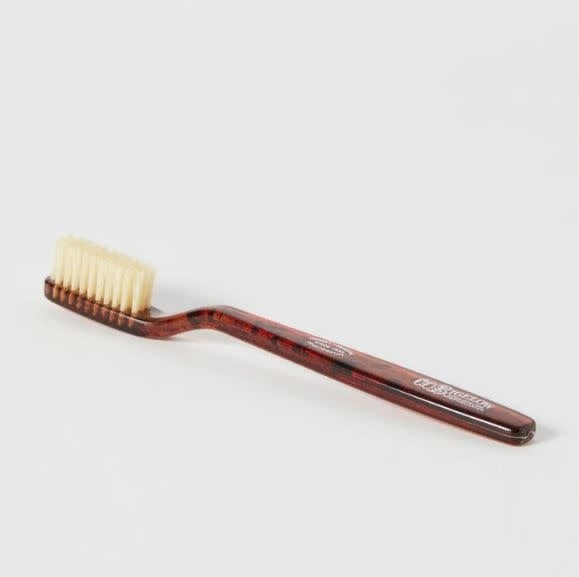 Natural boar bristle toothbrush with medium softness in a tortoise shell pattern handle.