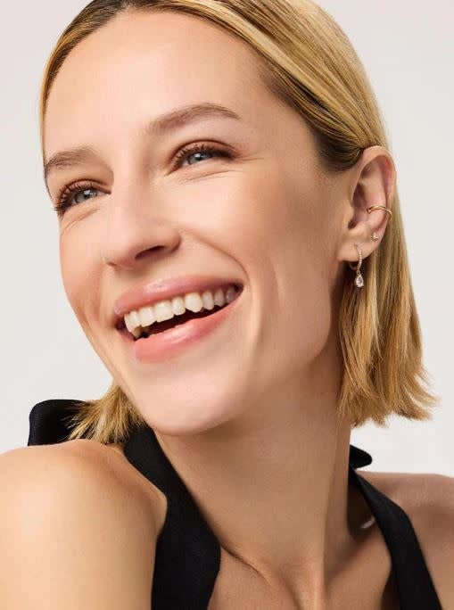 Gold-dipped huggie hoop earrings with cubic zirconia gems on a surgical steel post.