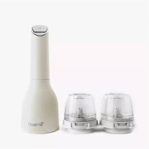 Soft cream FinaMill spice grinder with two attached Pro Plus pods on a kitchen counter.