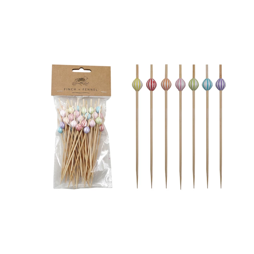 Set of bamboo cocktail picks with striped ball handles in natural wood tones.