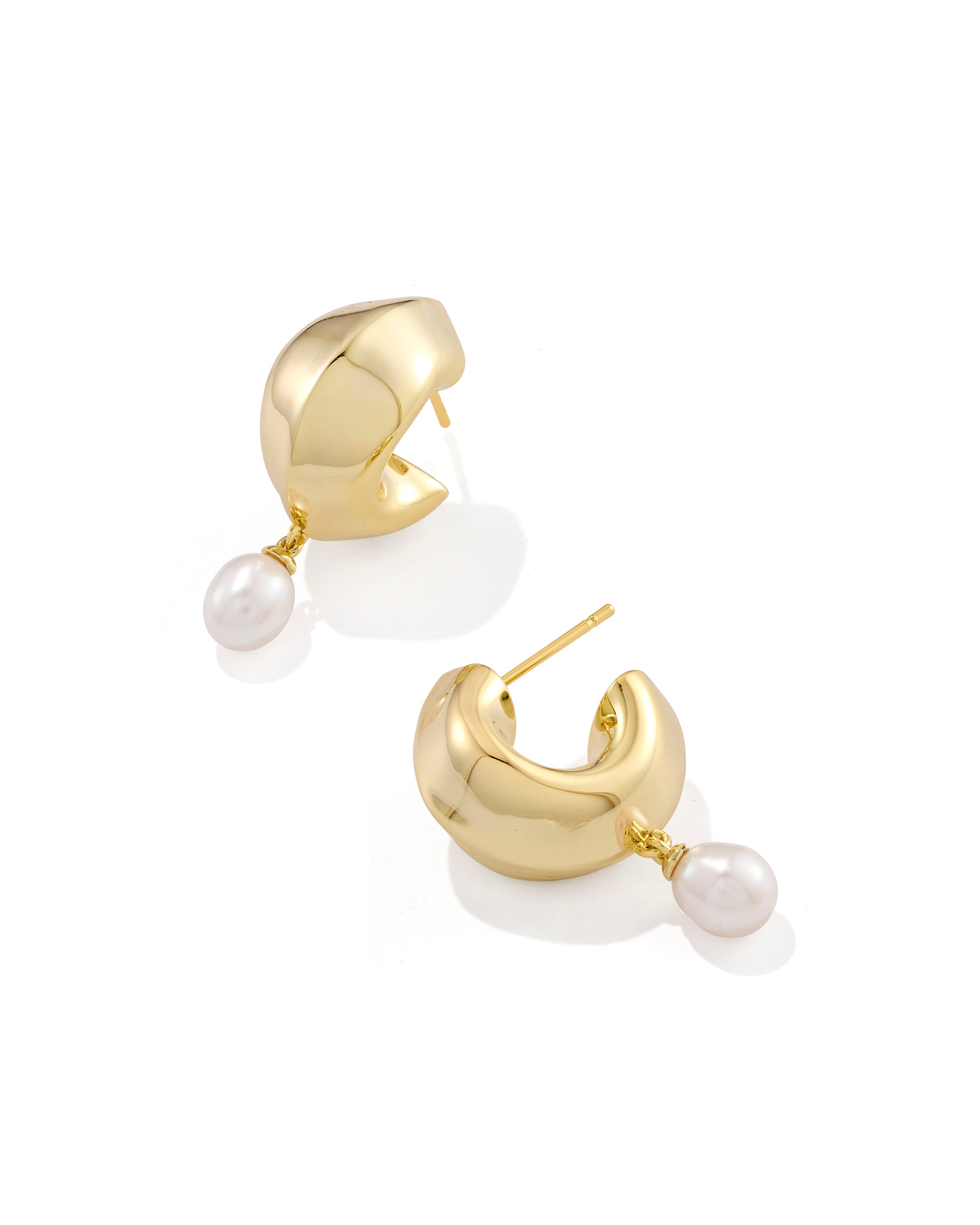 Oakland Pearl Huggie Earrings featuring chunky gold-tone hoops with dangling white pearls.