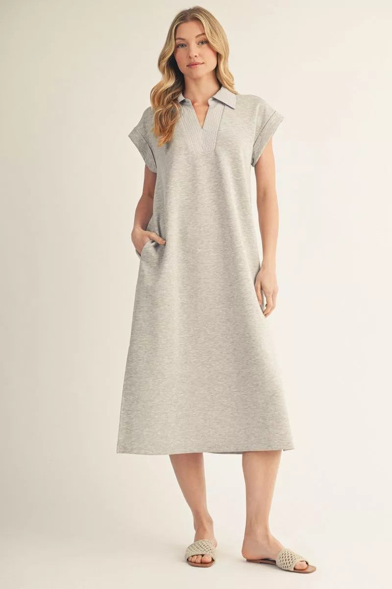Woman wearing a grey Madelyn short drop shoulder midi dress with a collar and side pockets.
