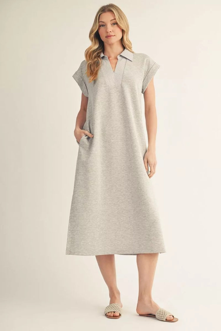 Woman wearing a grey Madelyn short drop shoulder midi dress with a collar and side pockets.