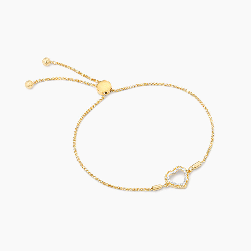 Adjustable stainless steel bolo bracelet with a gold-plated heart charm featuring diamond accents.