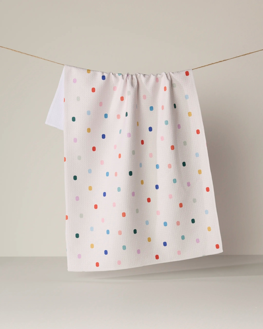 Everyday Tea Towel in white with a colorful multi-colored confetti dot pattern hanging on a line.