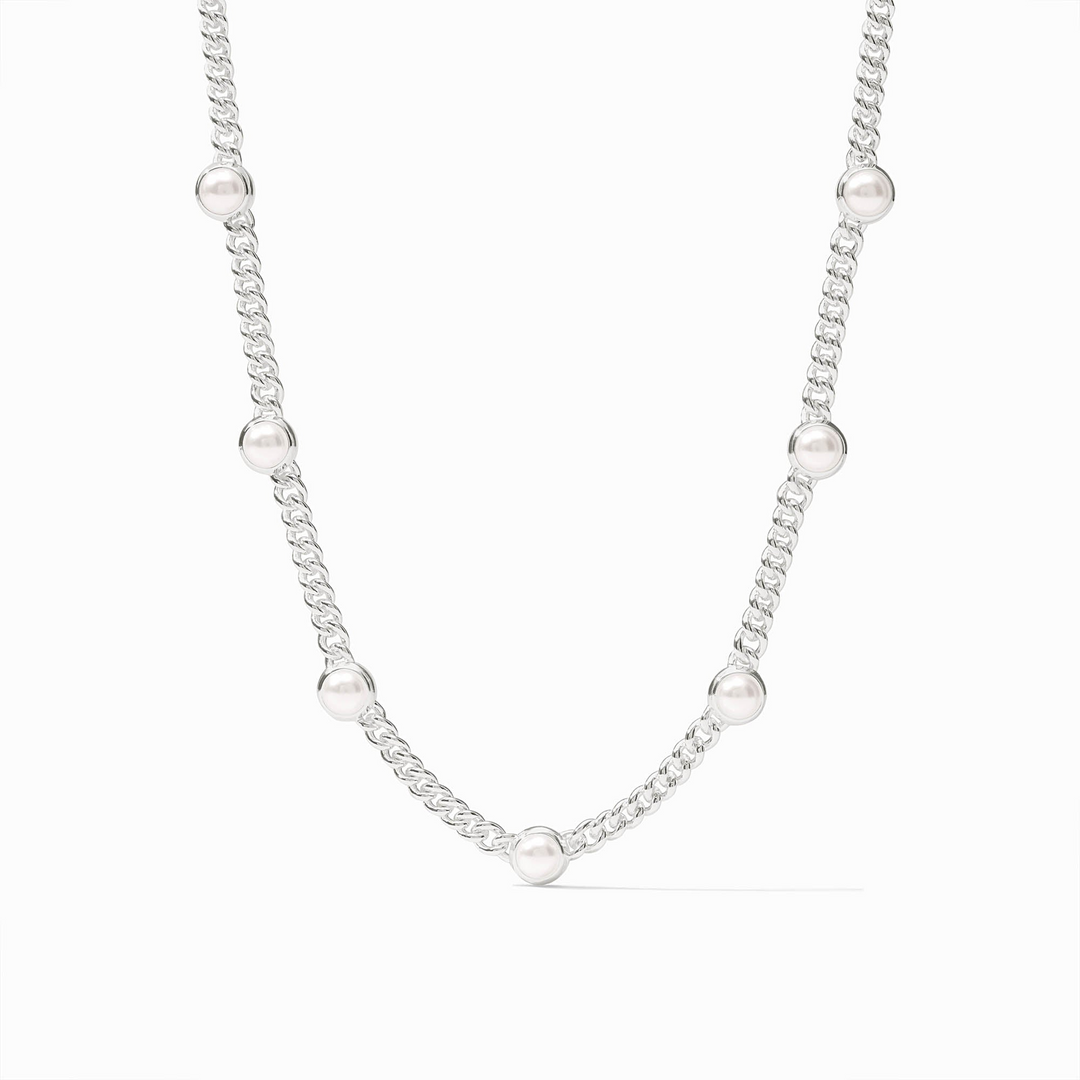 Silver chain necklace featuring seven evenly spaced white glass pearls in a station design.