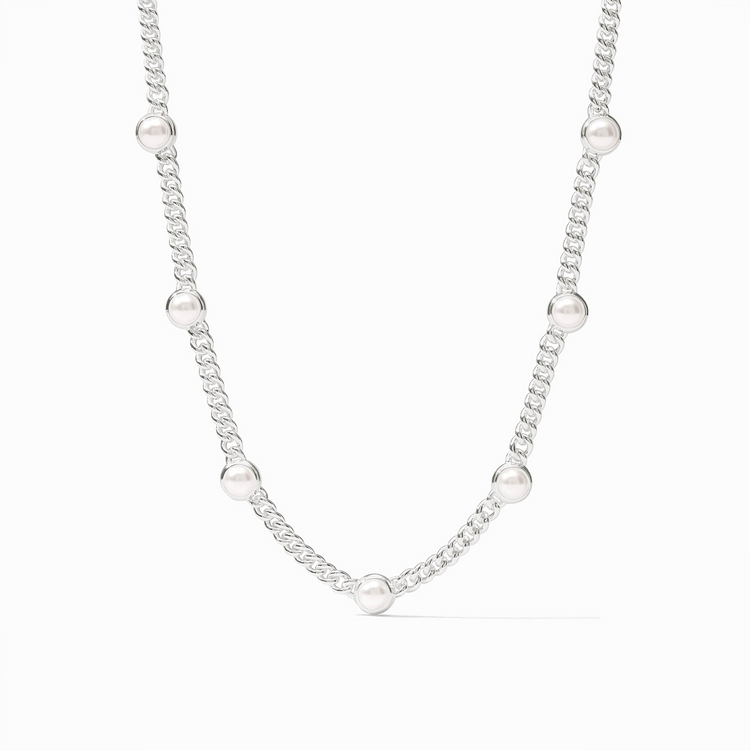 Silver chain necklace featuring seven evenly spaced white glass pearls in a station design.