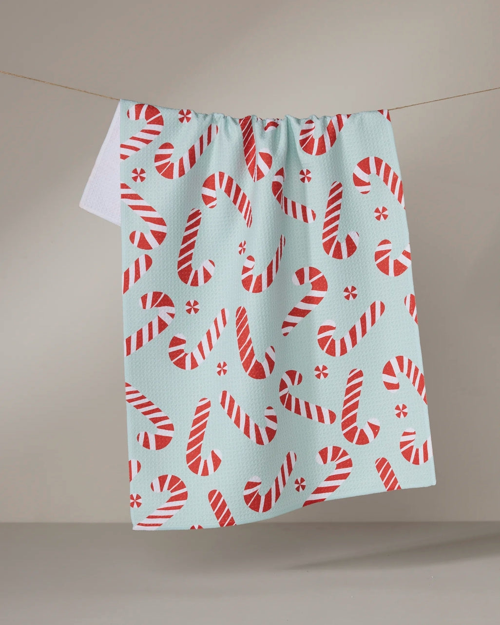 Holiday tea towel with waffle weave construction in red featuring a festive snowman pattern.