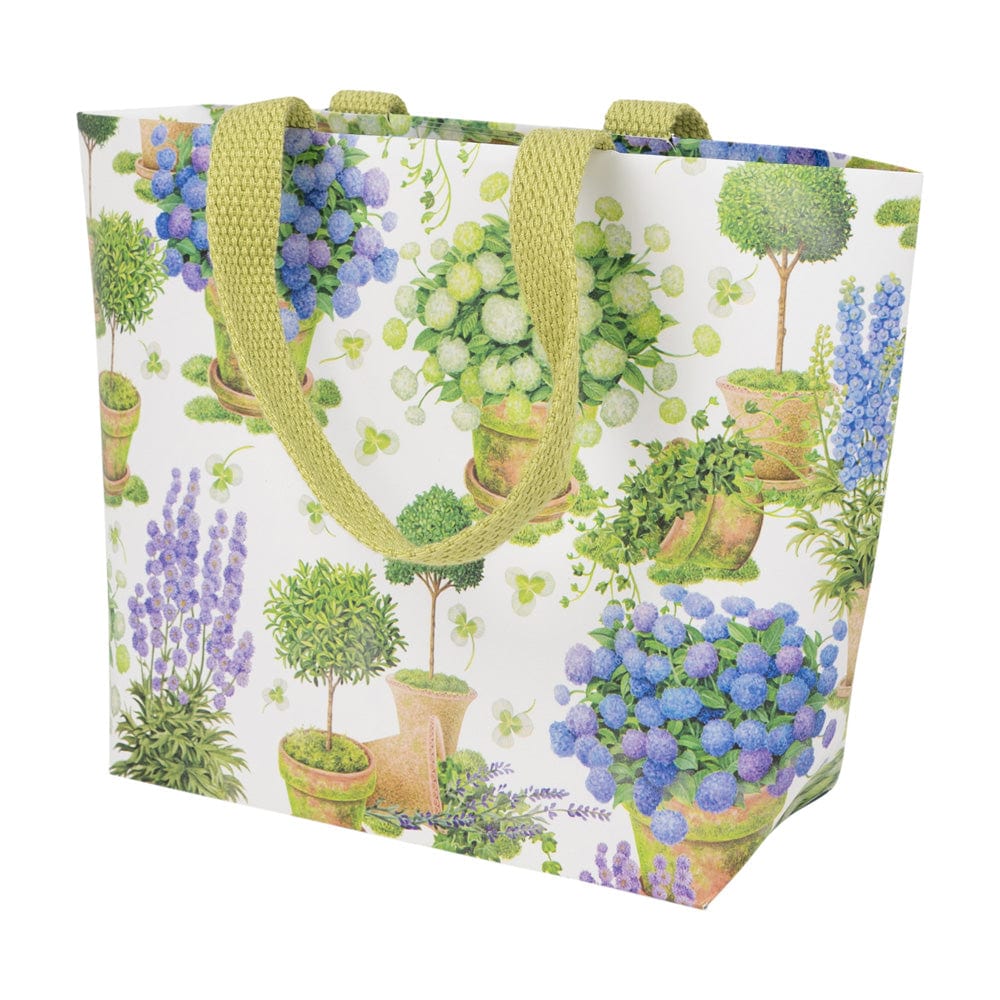 Small paper gift bag with a floral print of potted blue and white hydrangeas and green handles.