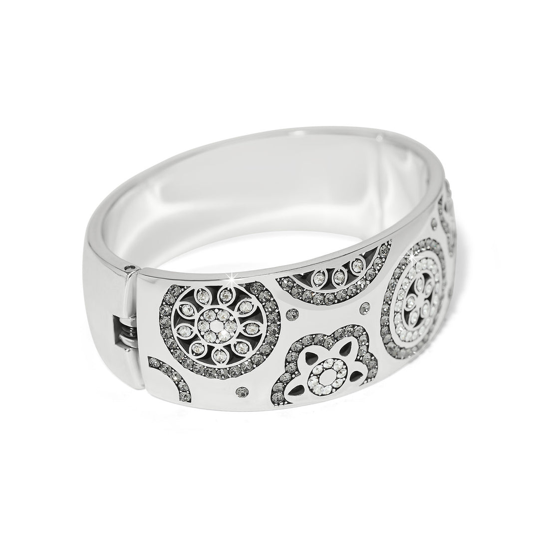 Silver plated wide hinged bangle bracelet featuring fine quality crystals in a bold feminine silhouette.