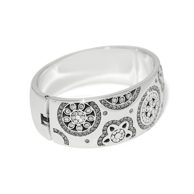 Silver plated wide hinged bangle bracelet featuring fine quality crystals in a bold feminine silhouette.